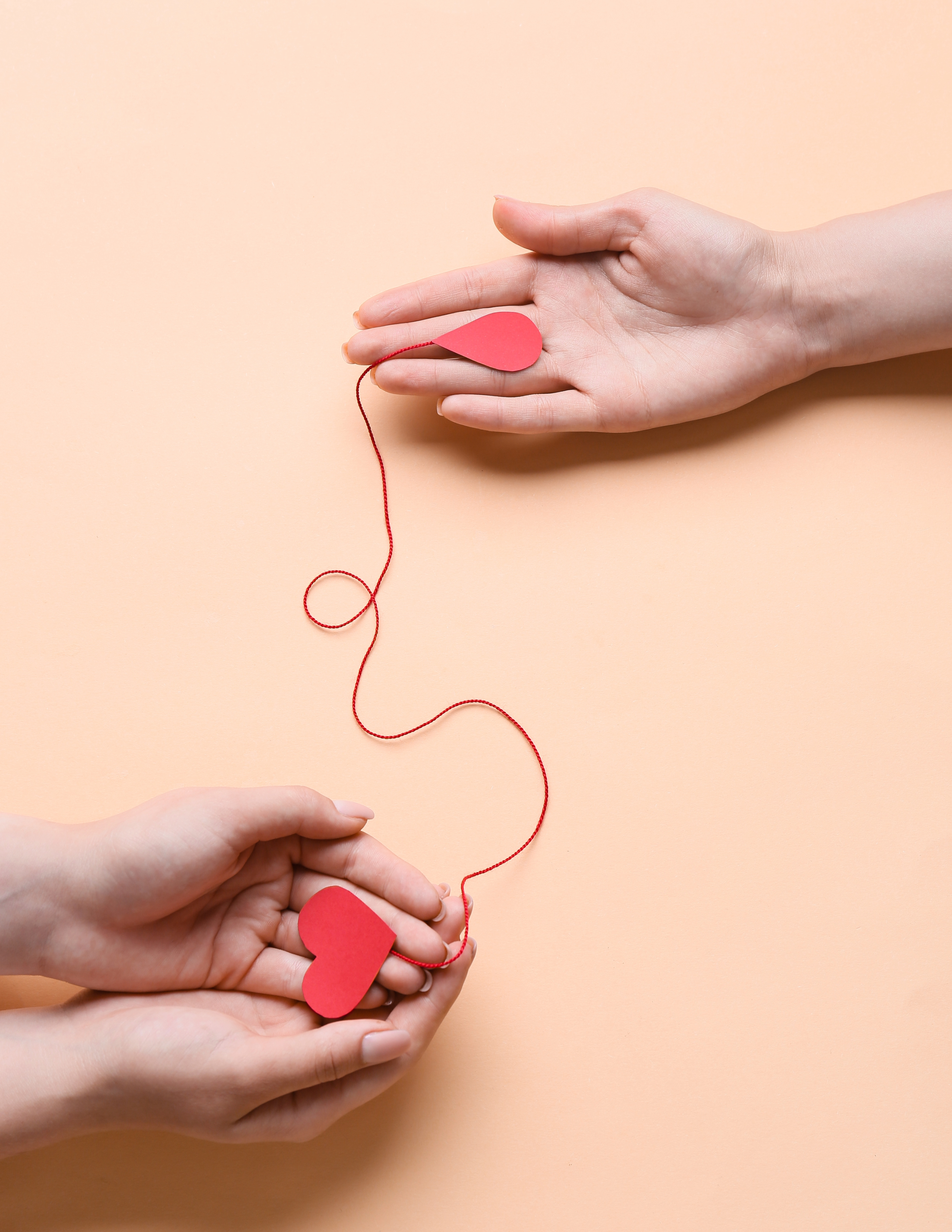A pair of hands hold a heart connected to a donor's hand.